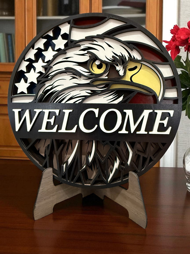 Decorative welcome sign with an eagle design on a wooden surface.