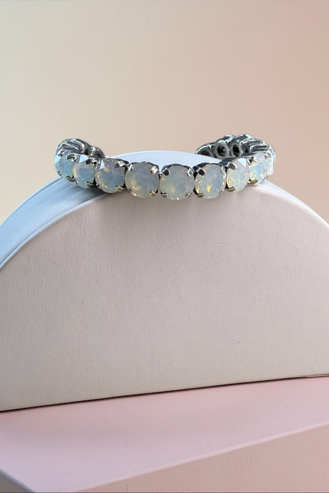 Silver white opal crystal bracelet on a pastel pink and beige background