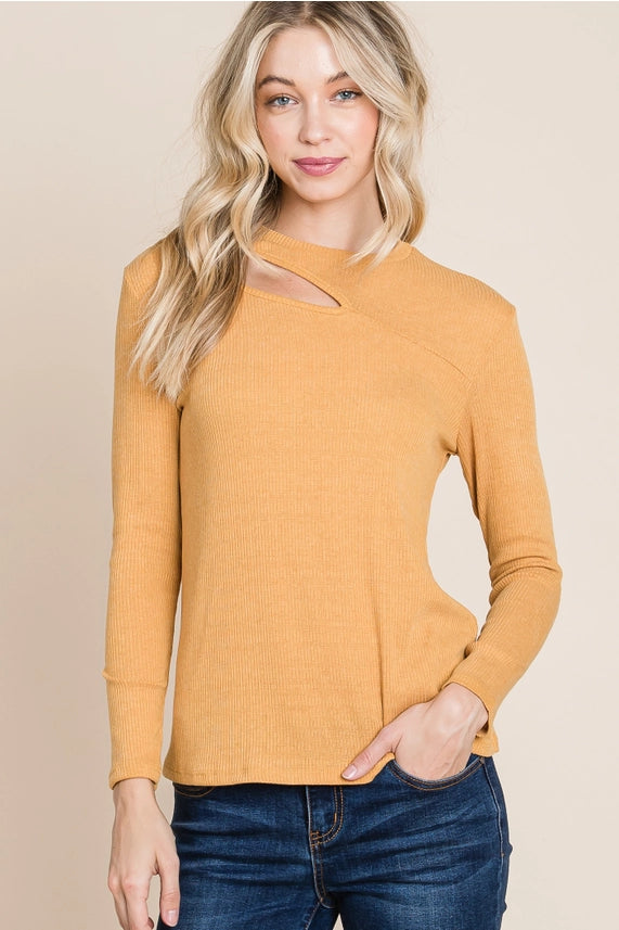 Woman wearing a mustard yellow sweater with a cutout design on a beige background